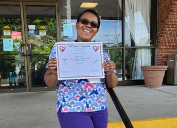 Woman holding large check CNA Program