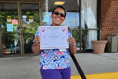 Woman holding large check CNA Program