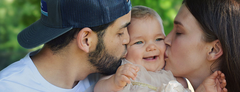 parents kissing baby